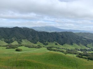 A landscape in Puerto Rico with lush green hills under a cloudy sky.